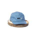 Blue BORA cap with embroidered front logo, front view on a wooden display stand