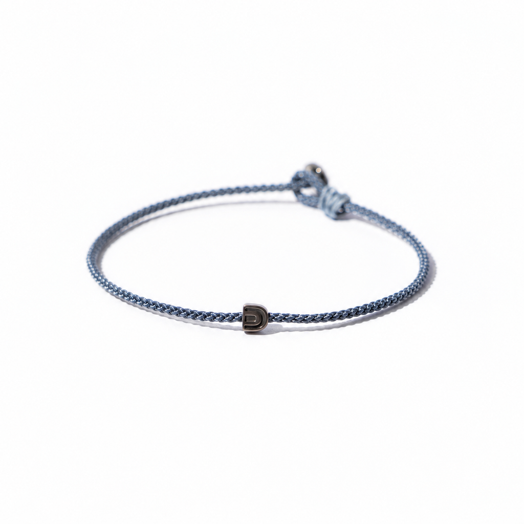 Blue BORA cord bracelet with a central arch-symbol bead and adjustable sliding knot