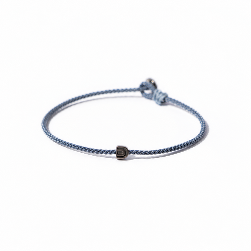 Blue BORA cord bracelet with a central arch-symbol bead and adjustable sliding knot